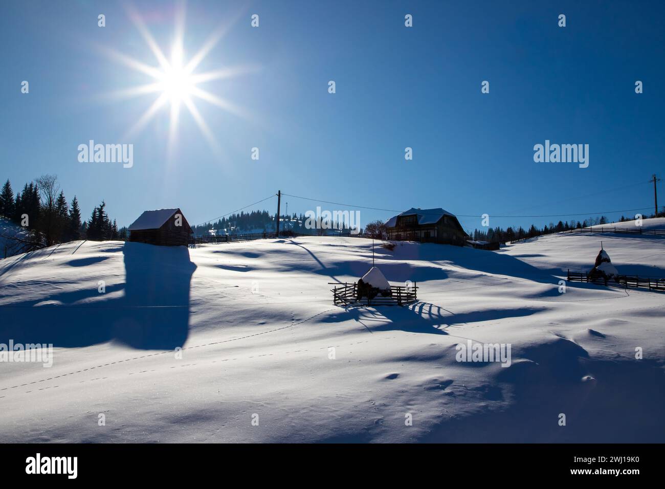 Un paysage avec une vieille maison isolée sur la pente d'une montagne couverte de neige, Roumanie. Banque D'Images
