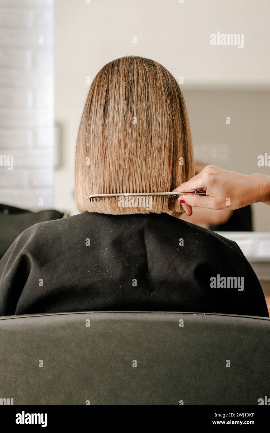Perfectionner une coupe de cheveux droite bob dans un salon de coiffure Banque D'Images
