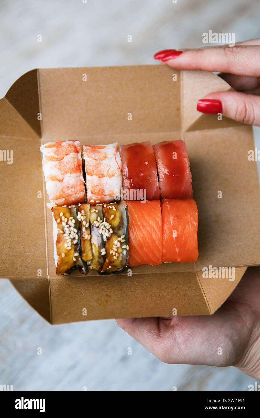 Sushi set sur la boîte d'emballage dans la main assortis rouleaux de sushi japonais Banque D'Images