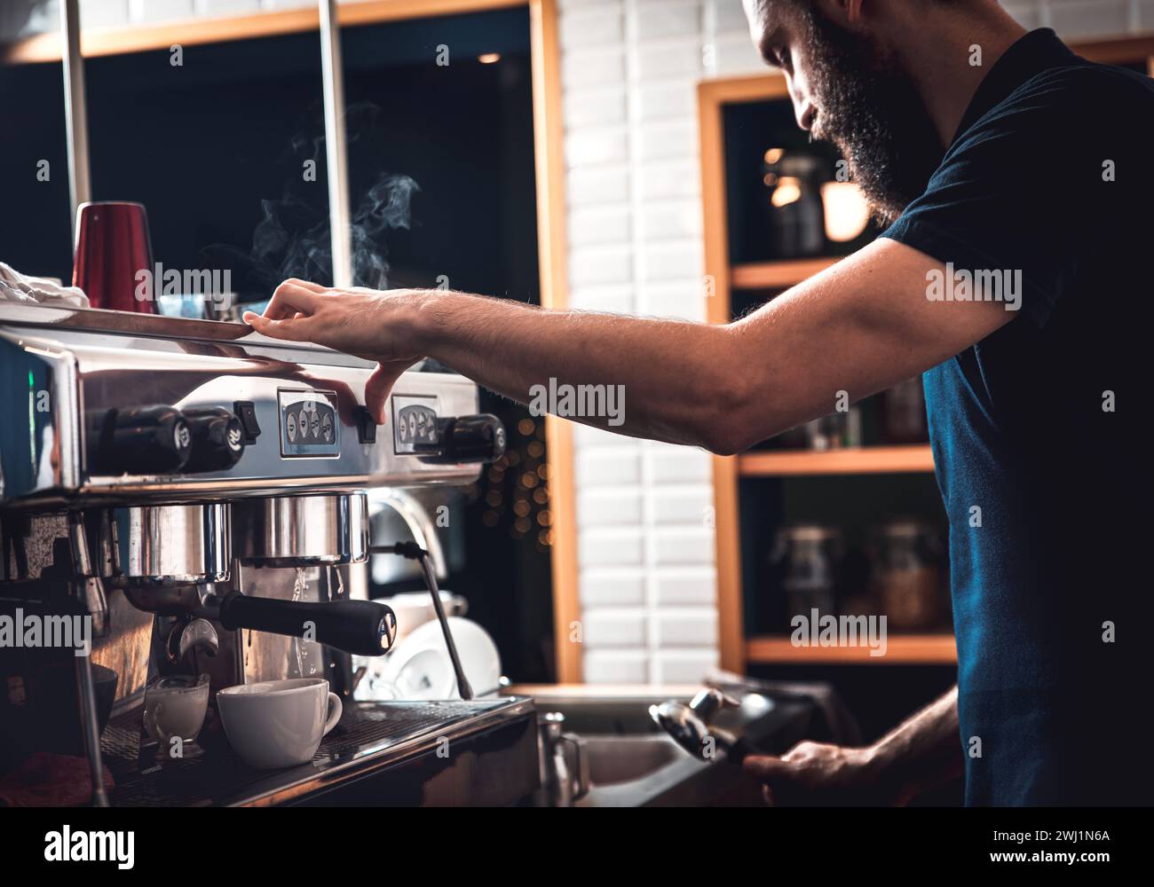 Gros plan des mains de barista préparant un cappuccino dans un gobelet en plastique pour le client au café. Banque D'Images