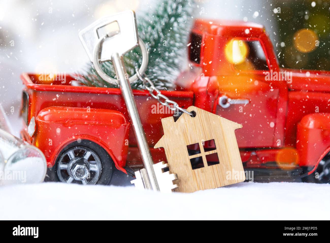 Voiture rétro rouge avec un arbre de Noël décorera avec la clé de la maison dans le pick-up pour Noël. Achat d'une maison, déménagement, morg Banque D'Images