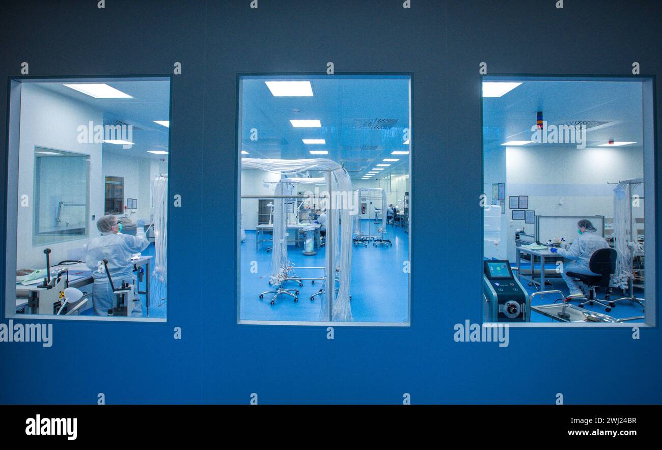 Schwerin, Allemagne. 12 février 2024. Dans la salle blanche de la société Human Med AG, des tubes sont préparés pour être assemblés dans des dispositifs médicaux de liposuccion. L’entreprise basée à Schwerin et l’Université et le Centre médical universitaire Rostock travaillent ensemble sur ce projet. Le dispositif utilise des vibrations ou un jet d'eau pour aspirer la graisse du corps humain et est utilisé dans le traitement chirurgical du lipoœdème, un trouble de la distribution de graisse. Crédit : Jens Büttner/dpa/Alamy Live News Banque D'Images