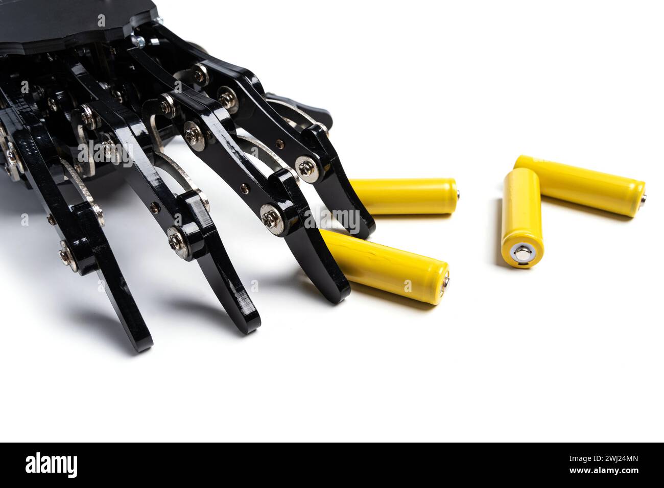 Véritable main robotique et piles AA rechargeables sur fond blanc Banque D'Images