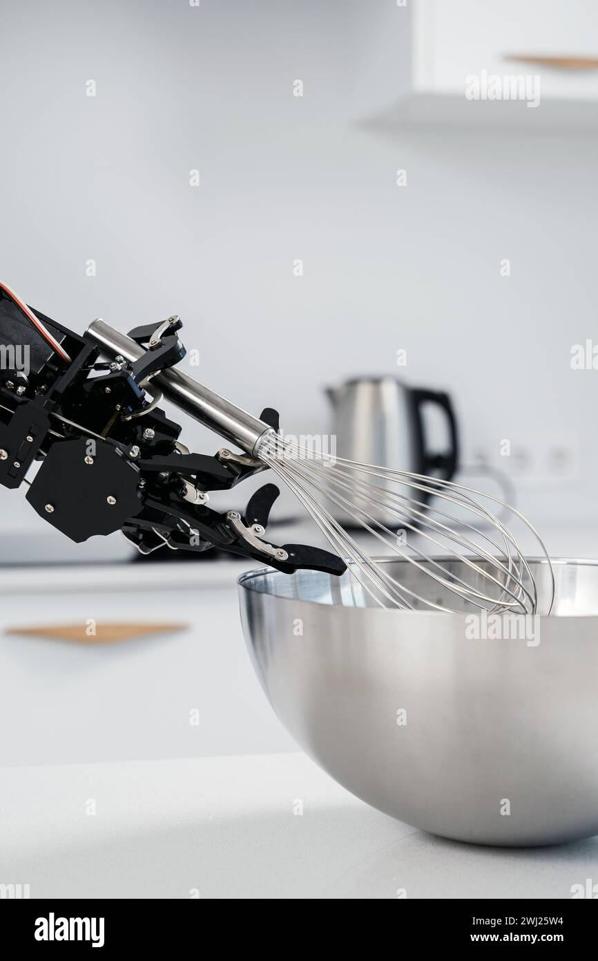 Véritable main de robot et fouet en acier inoxydable. Concept d'automatisation de processus robotisée. Banque D'Images