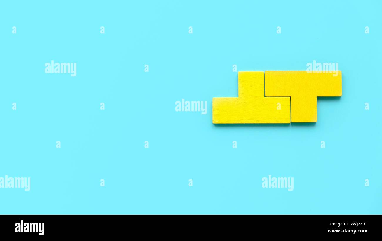 Vue de dessus deux pièces de puzzle jaune isolé sur un fond bleu avec espace de copie. Banque D'Images