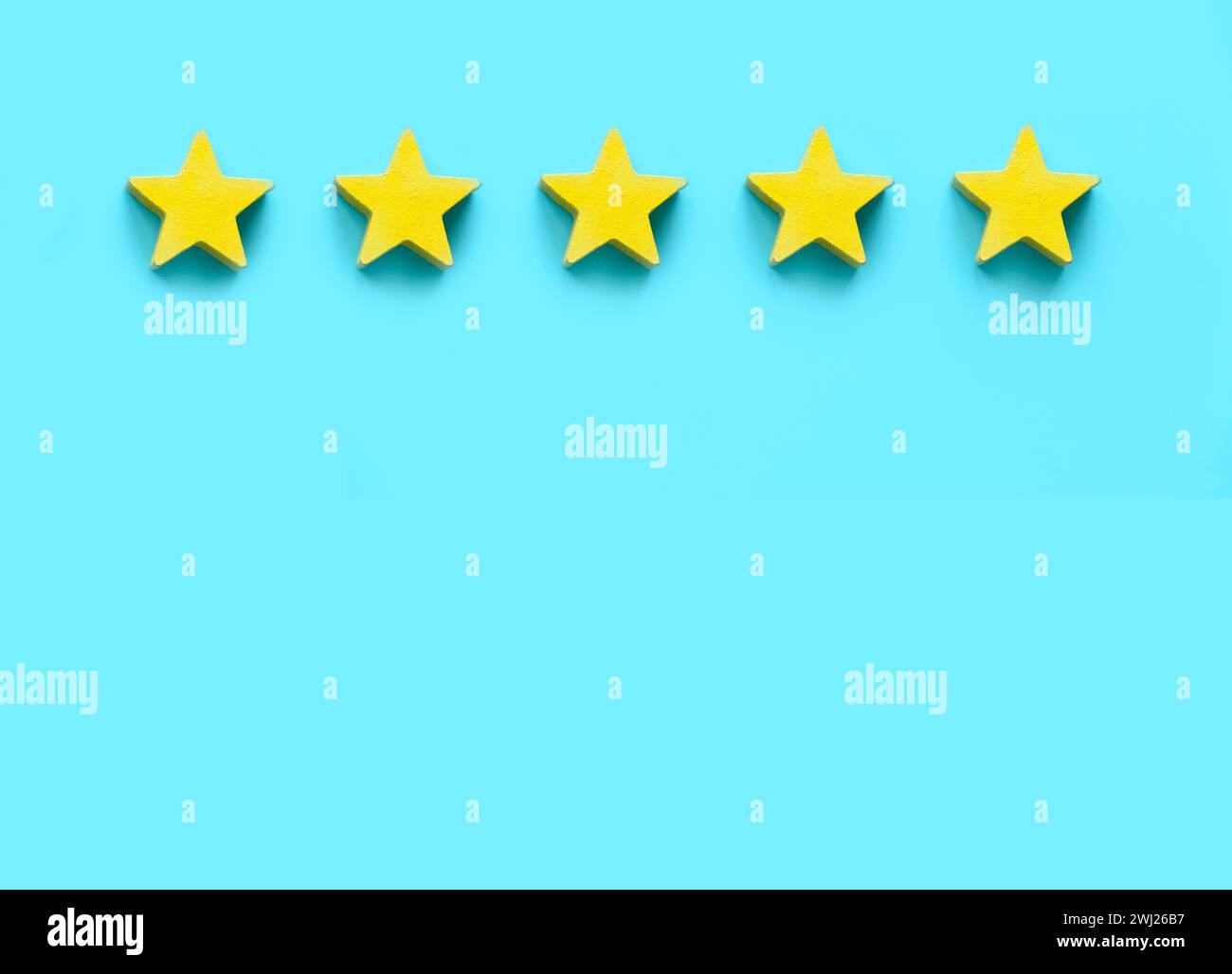 Commentaires des clients, évaluation des produits, satisfaction de l'expérience client. Cinq étoiles en bois jaune sur fond bleu avec espace de copie. Banque D'Images