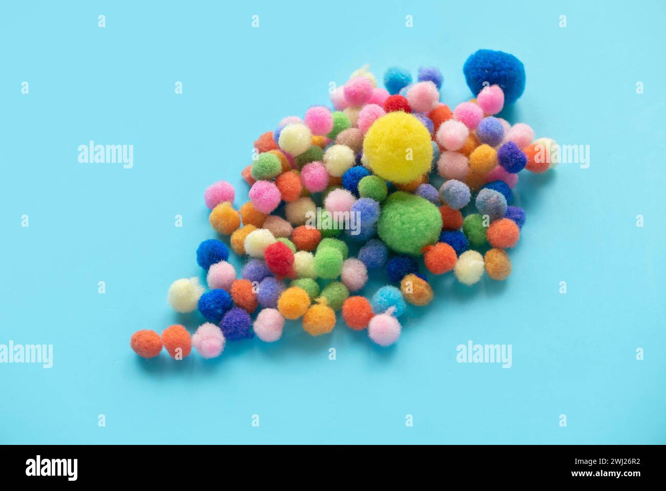 Pompon coloré boule de coton isolé sur fond bleu. Pour montessori. Banque D'Images