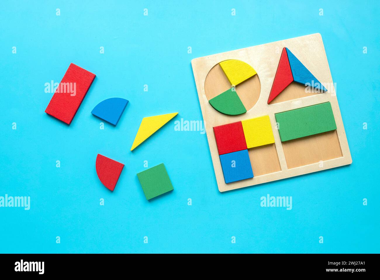 Jouets éducatifs, compétences cognitives, concept de pensée logique de développement d'enfant. Colorés Montessori formes géométriques jouets sur un fond bleu.Sorter Banque D'Images