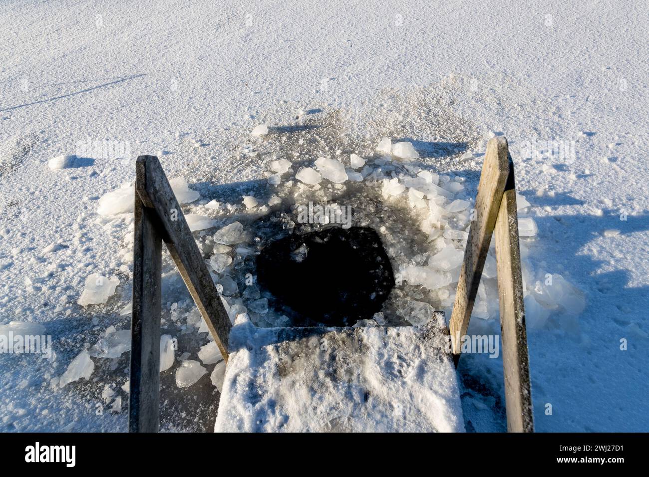 Passerelle et trou dans la glace pour se baigner dans un lac gelé en Scandinavie Banque D'Images