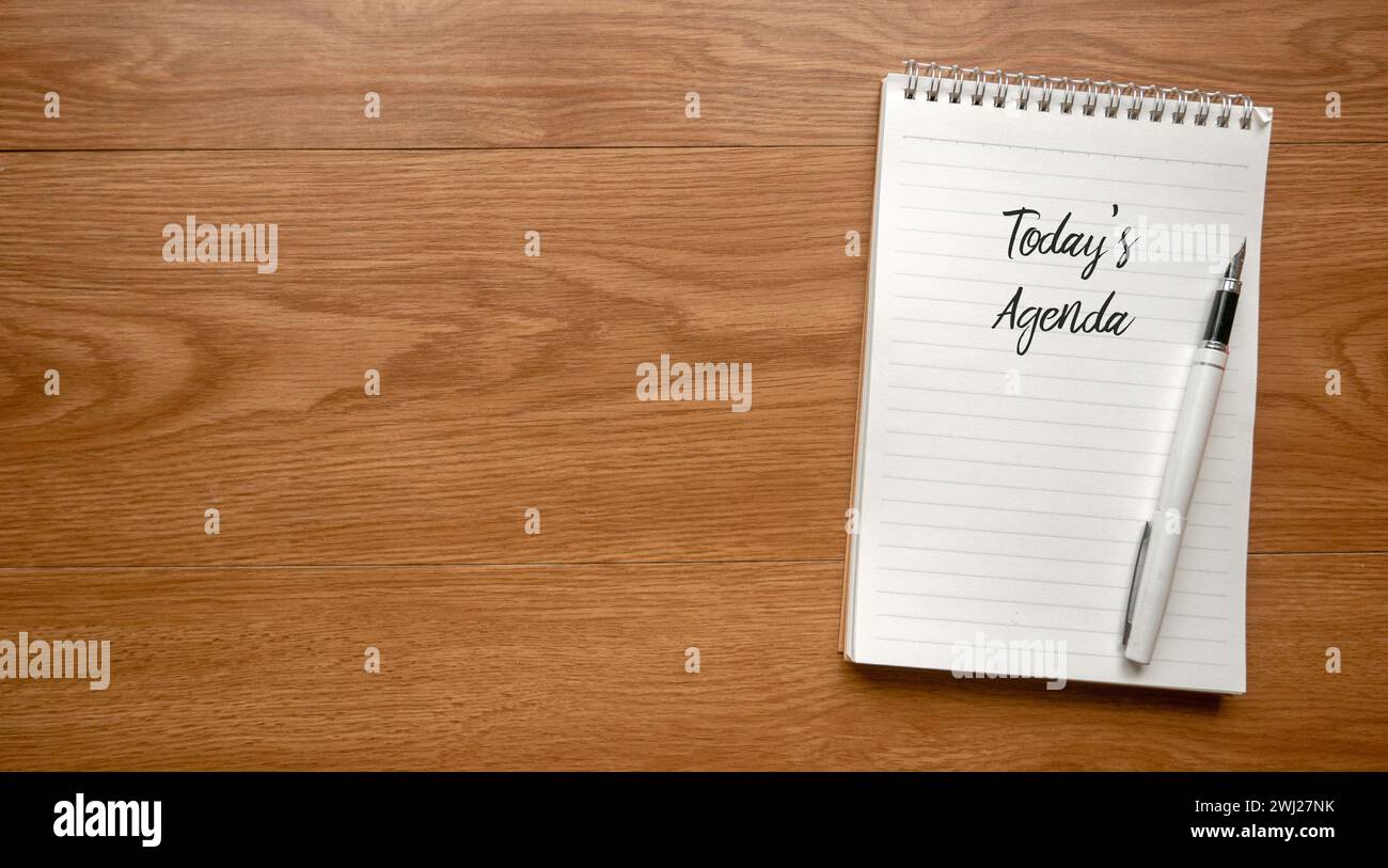 Vue de dessus du stylo et du cahier écrit avec l'Agenda d'aujourd'hui sur fond en bois avec espace de copie. Banque D'Images