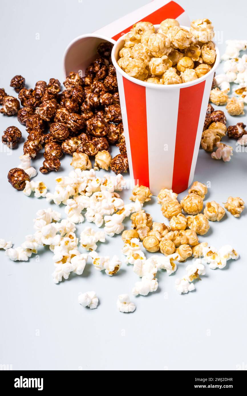 Assortiment de pop-corn dans une tasse rouge blanche rayée en papier. Pop-corn sucré et salé Banque D'Images
