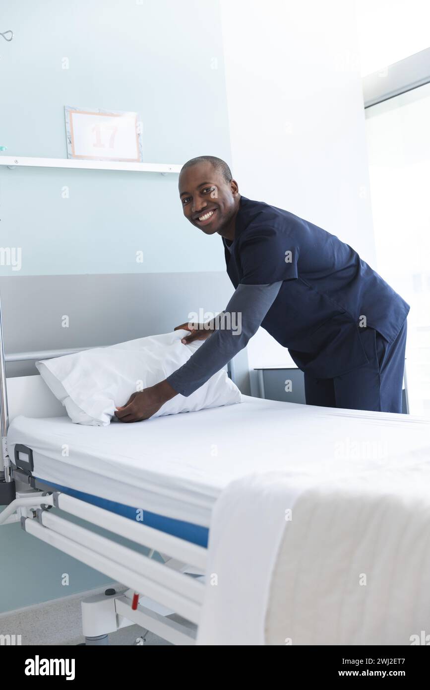 Portrait d'un médecin afro-américain heureux portant des gommages faisant lit dans une chambre d'hôpital Banque D'Images