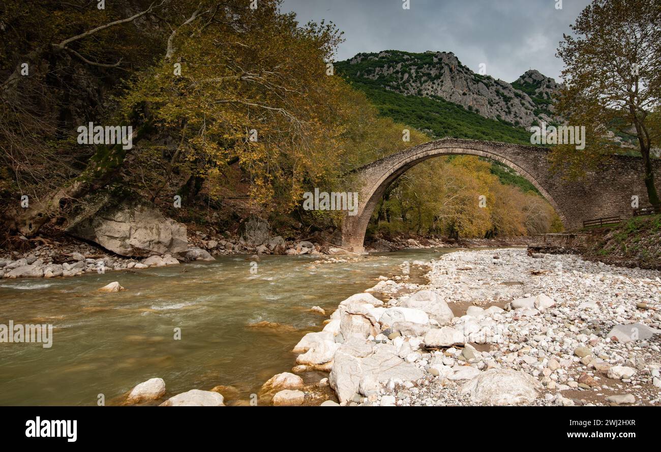 Ancien pont voûté, lapidé, sur la rivière Portaikos en automne. Trikalla pyli village Thessalie Grèce Banque D'Images