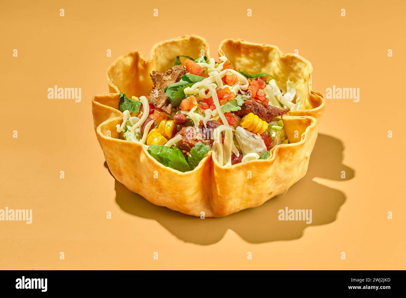 Salade de tacos dans un bol de tortilla avec du bœuf, du fromage, du maïs et de la laitue Banque D'Images
