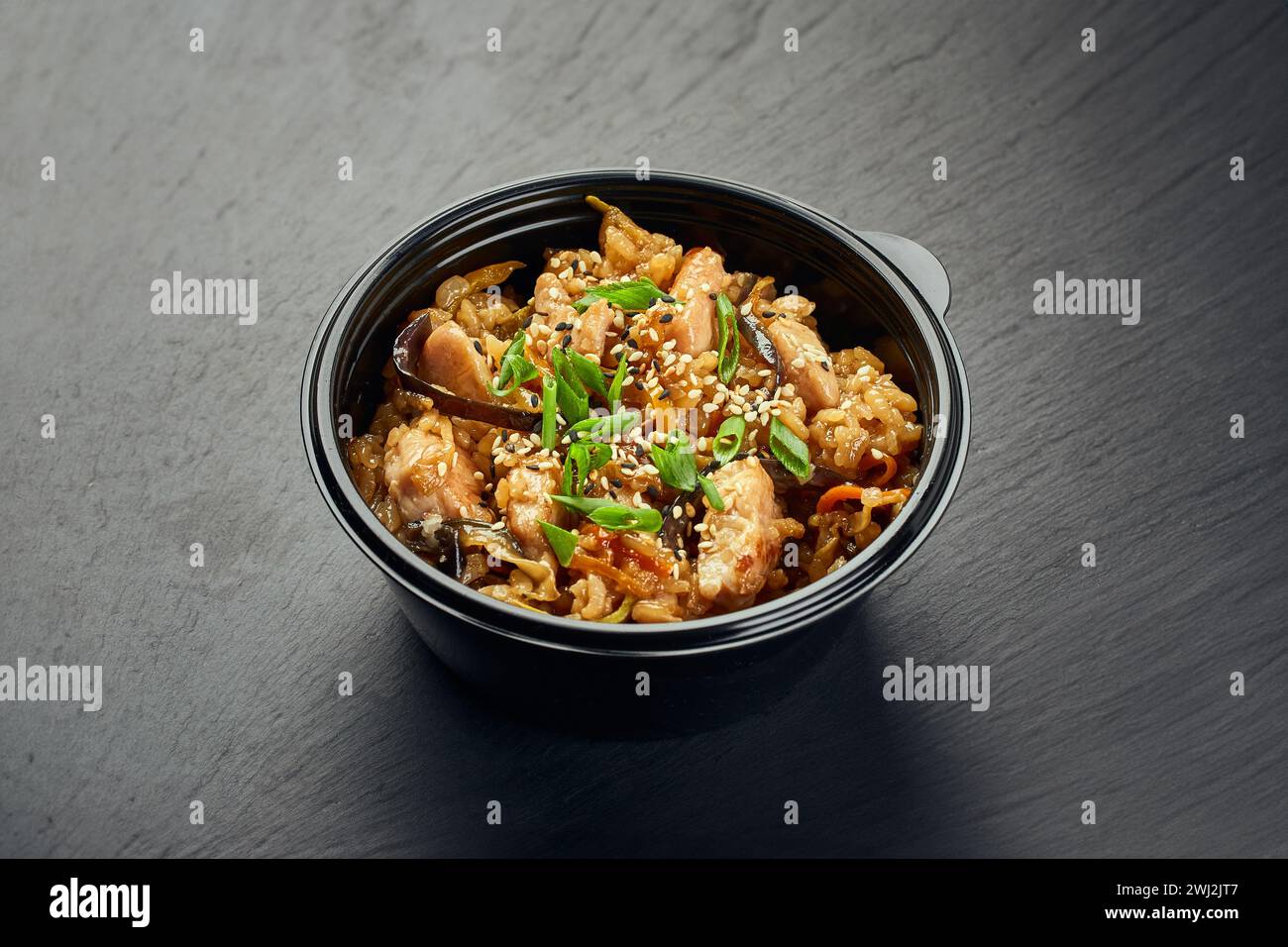 Plat traditionnel asiatique, poulet ou porc avec riz et champignons dans un bol en plastique Banque D'Images