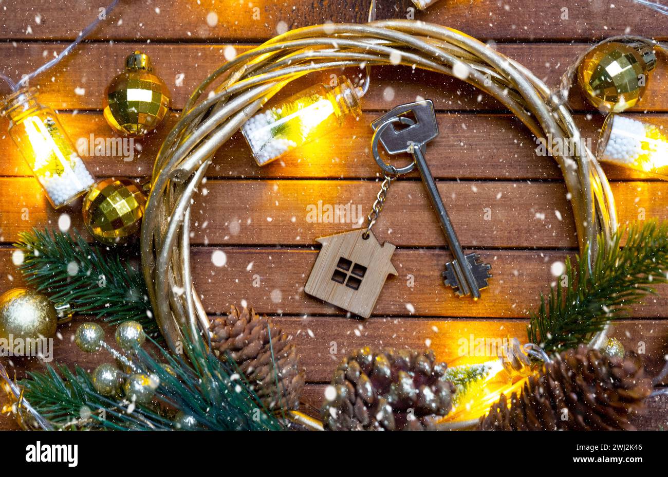 Clé de la maison avec porte-clés sur fond de bois brun confortable avec disposition de décor de Noël. Cadeau pour le nouvel an, Noël. Bâtiment, Banque D'Images