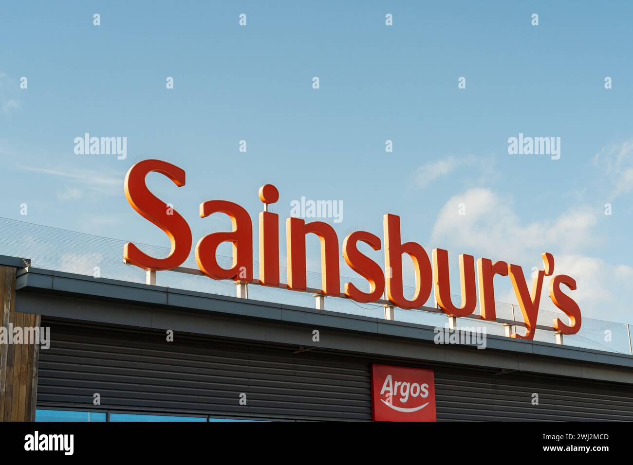 Wolverhampton, Angleterre – 12 février 2024 : signalisation frontale de la chaîne de supermarchés britannique, Sainsbury's, incluant le logo Argos comme point de collecte Banque D'Images