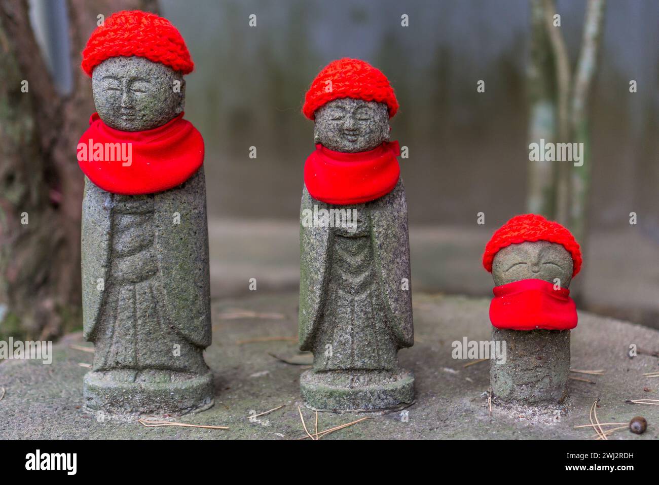 3 petites statues de moine avec des chapeaux tricotés rouges et des foulards au temple Rinnō-ji à Sendai, Japon Banque D'Images
