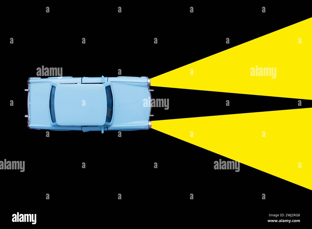 Modèle de jouet de voiture rétro bleu clair et concept de phare de lampe au xénon sur fond noir. Louer une voiture, Banque D'Images