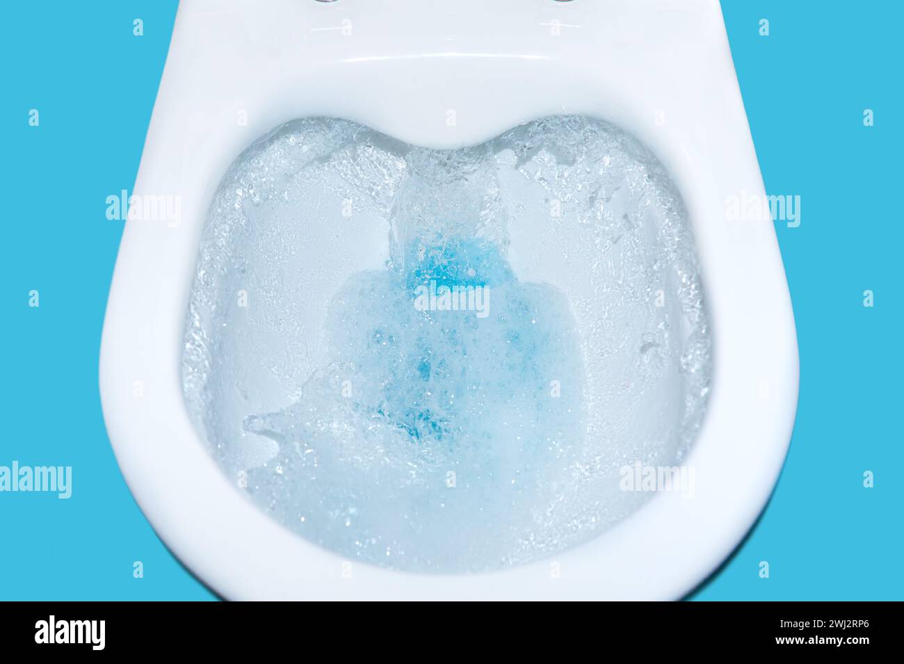 Chasse d'eau pour cuvette de toilettes avec liquide de nettoyage bleu isolé. Nettoyage des toilettes en gros plan. Pollueur environnemental Banque D'Images