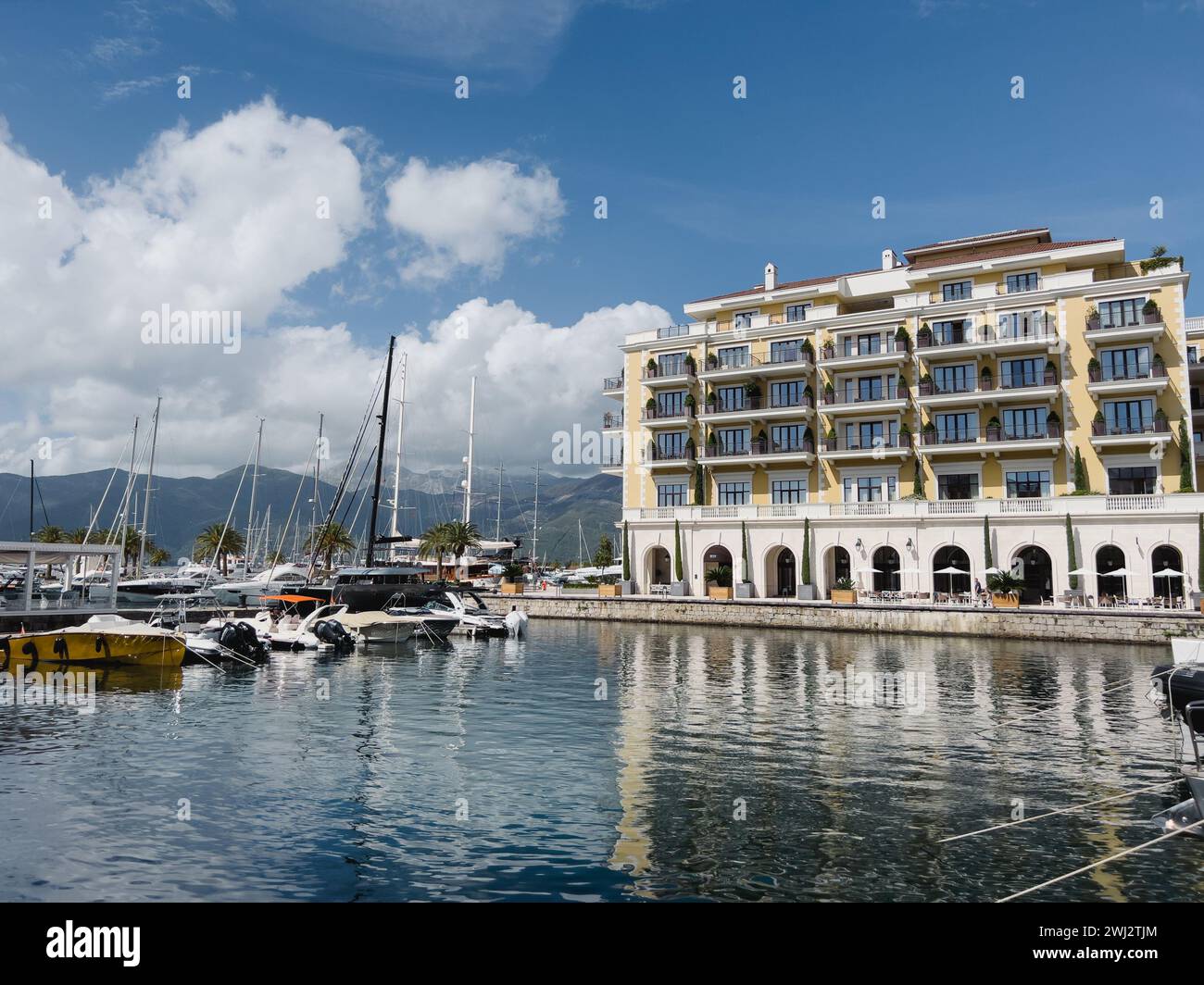 Tivat, Monténégro - 11 août 2023 : remblai de l'hôtel Regent avec des arbres verts dans des baignoires près de la marina avec des yachts Banque D'Images