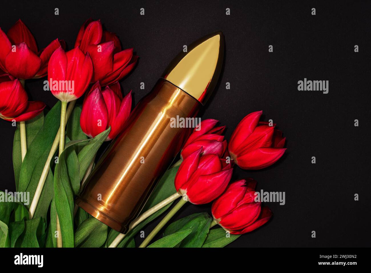 Pacifisme, mouvement de non-violence ou jour de la victoire. Balle et bouquet de tulipes rouges. Banque D'Images