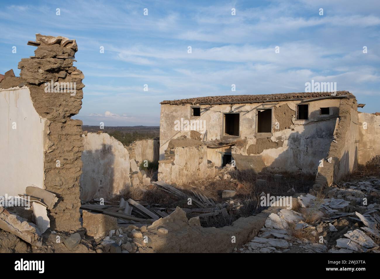 Maison de ferme abandonnée et s'effondrant en plein air. Ruines de l'architecture traditionnelle en argile. Lieux déserts Banque D'Images