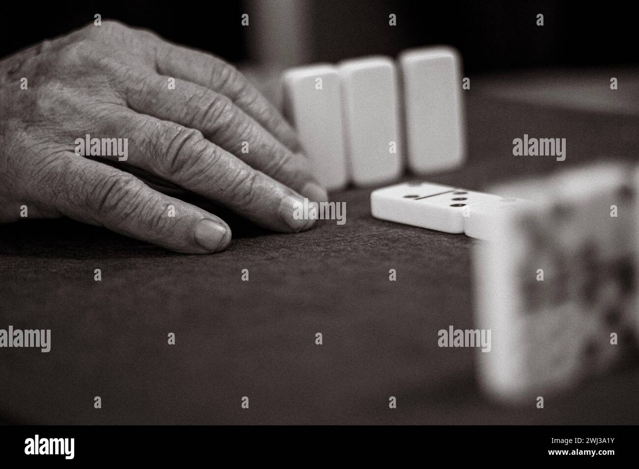 Gros plan d'une personne âgée méconnaissable avec des rides et des veines jouant un jeu de dominos Banque D'Images