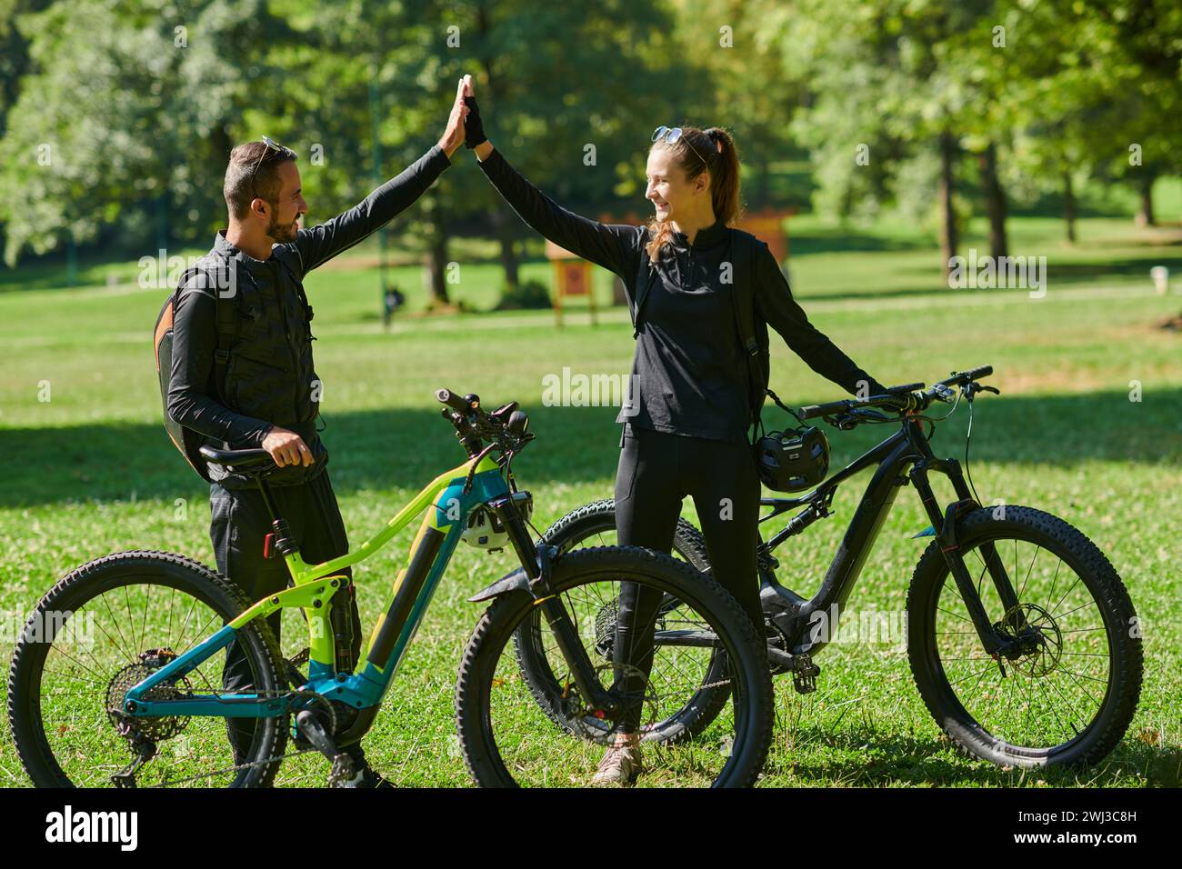 Un couple doux, orné d'équipement de cyclisme, monte leurs vélos, leurs mains imbriquées dans une étreinte romantique, capturant la esse Banque D'Images