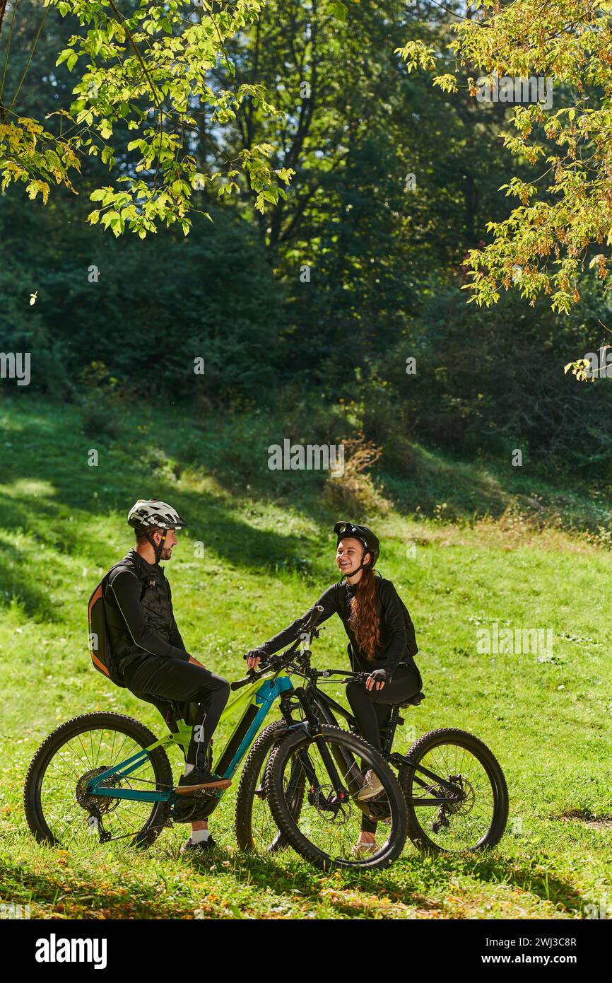 Un couple doux, équipé de vélos et engrossé dans la coordination de leur voyage, vérifie leur GPS mobile et montres pendant pl Banque D'Images