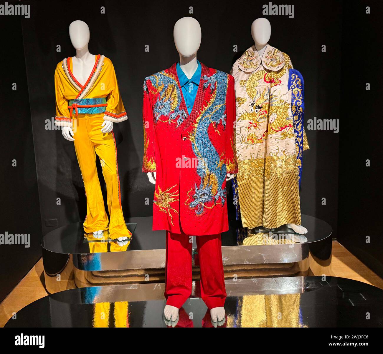New York, New York, États-Unis. 12 février 2024. (L) combinaison et veste inspirées par le kimono polyester jaune moutarde, probablement Bob Mackie, vers 1975, estimé entre 4 000 $ et 6 000 $, (C) combinaison ''˜Dragon chinois' conçue par Keith Gregory Fleming - Haberstroh, 3 000 $ - 5 000 $, et (l) Robe de soie à broderies chinoises 1 000 $ - 1 500 $ vue chez ''˜The Collection of Sir Elton John: Goodbye Peachtree Road' au Christie's Rockefeller Center. Les objets proviennent de l'ancienne maison d'Elton à Atlanta. (Crédit image : © Nancy Kaszerman/ZUMA Press Wire) USAGE ÉDITORIAL SEULEMENT! Non destiné à UN USAGE commercial ! Banque D'Images