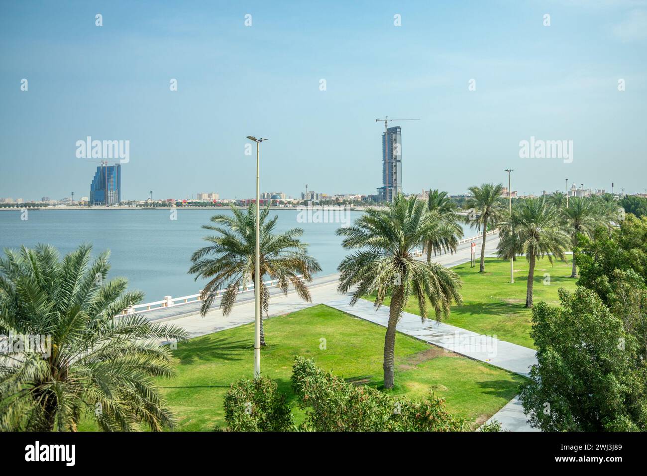 Parc de corniche du littoral de Dammam avec palmiers et ville en développement en arrière-plan, Arabie Saoudite Banque D'Images