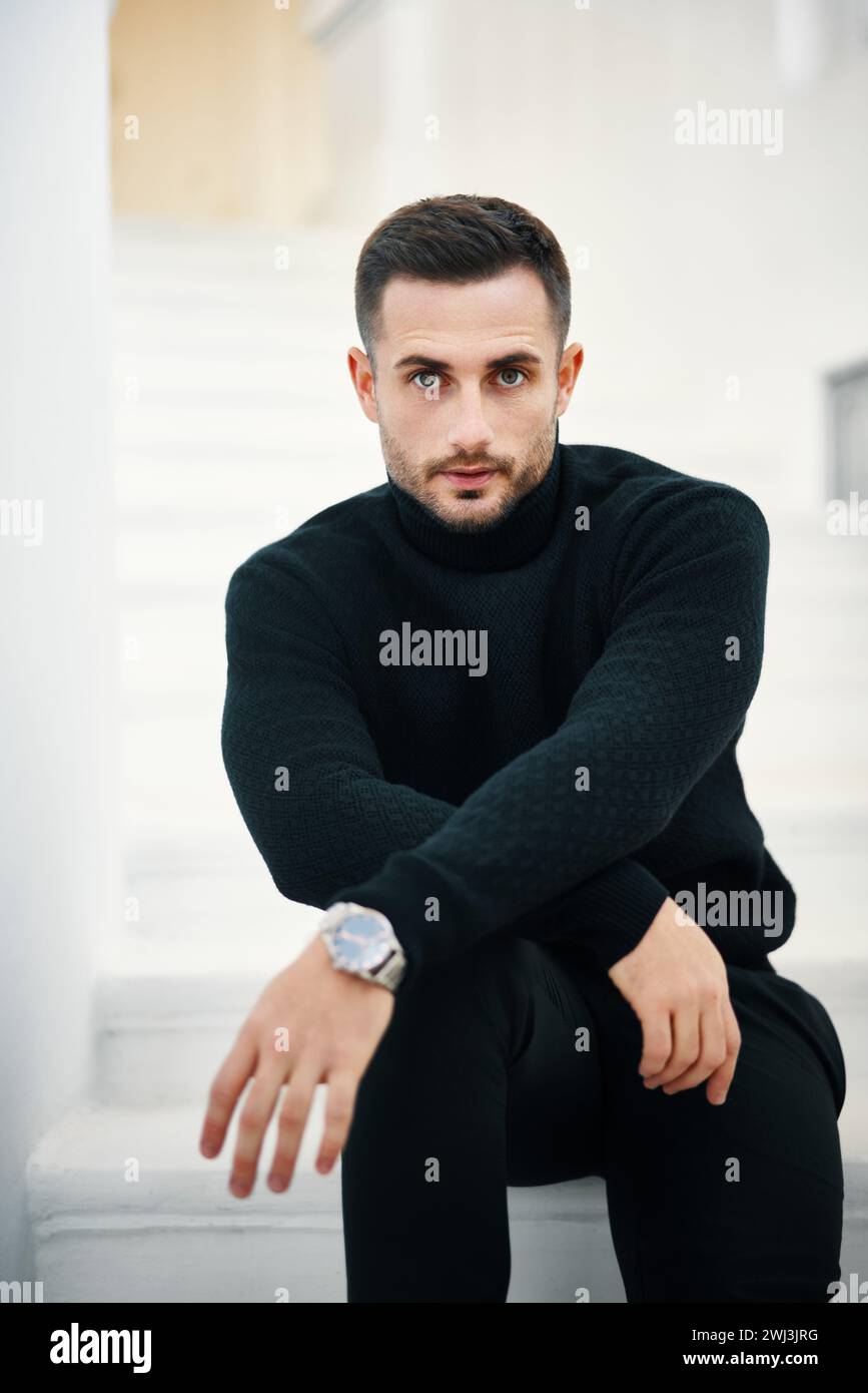 Portrait de beau jeune homme dans une tenue de vêtements noirs sur fond blanc moderne Banque D'Images