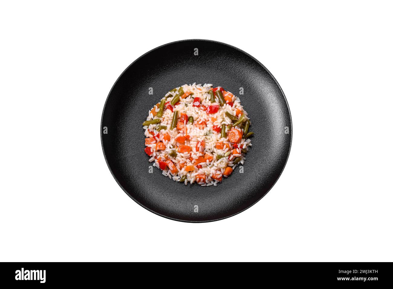 Délicieux risotto frais avec légumes, épices et herbes sur une assiette noire Banque D'Images