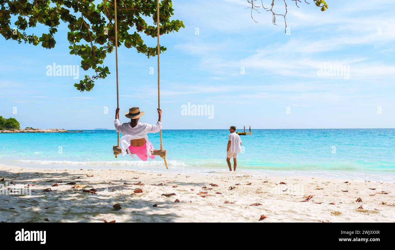 Un couple d'hommes et de femmes à une balançoire sur la plage de Koh Samet île Rayong Thaïlande Banque D'Images