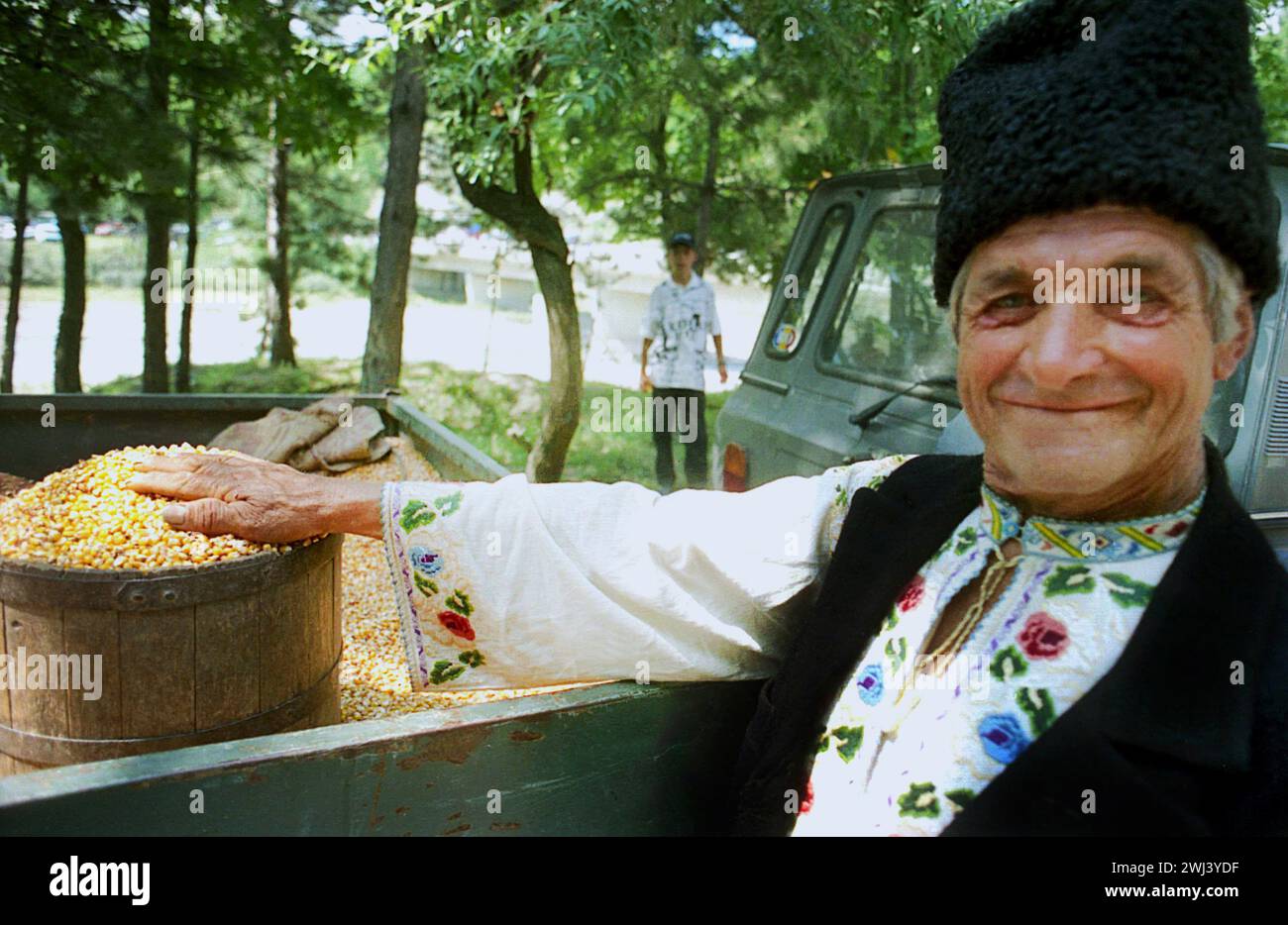 Comté de Vrancea, Roumanie, approx. 1998. Homme vendant des graines de maïs sèches à une foire de campagne. Banque D'Images