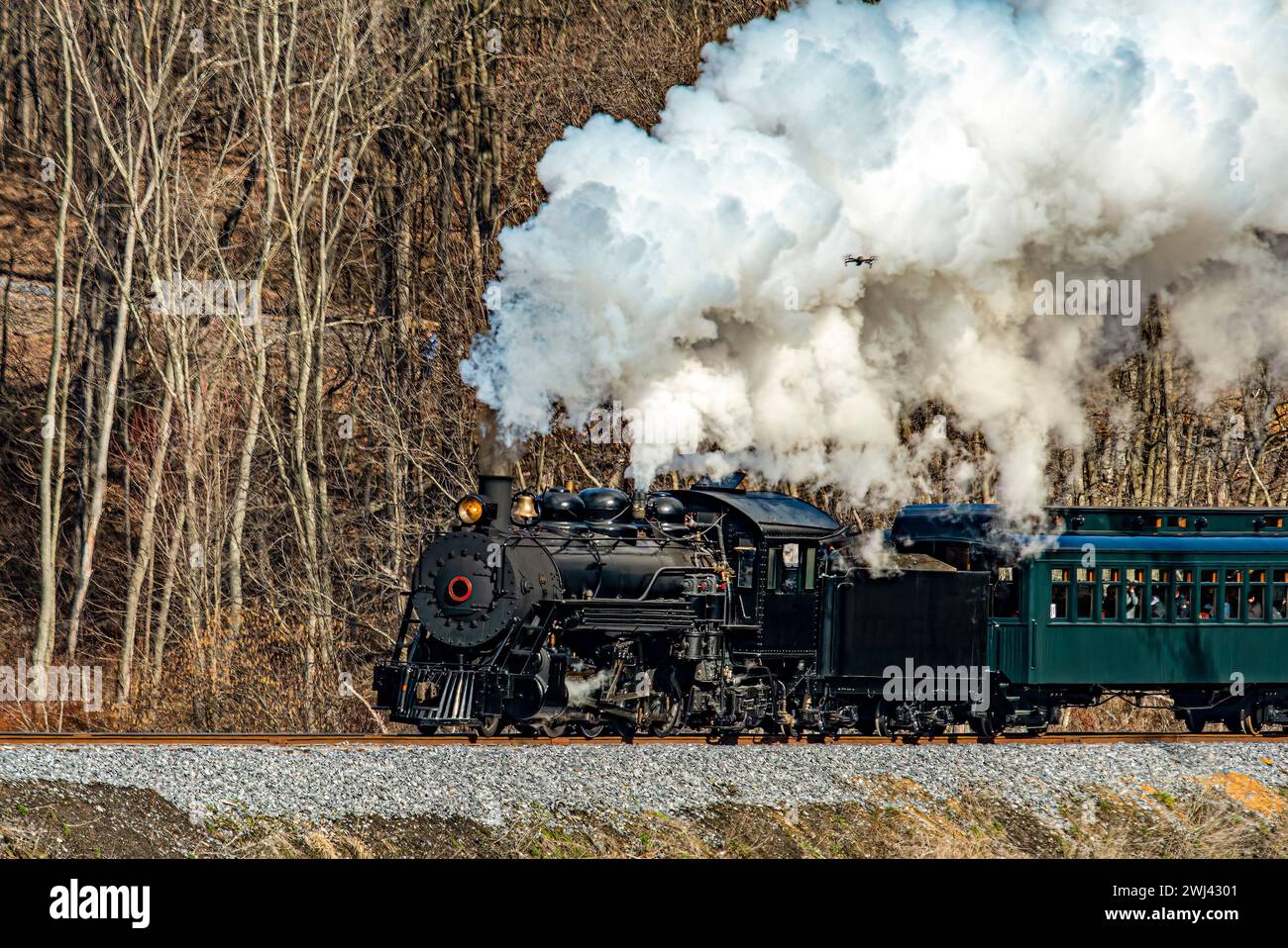 Vue d'un train de passagers à vapeur à voie étroite restauré soufflant de la fumée et voyageant à travers des terres agricoles Banque D'Images