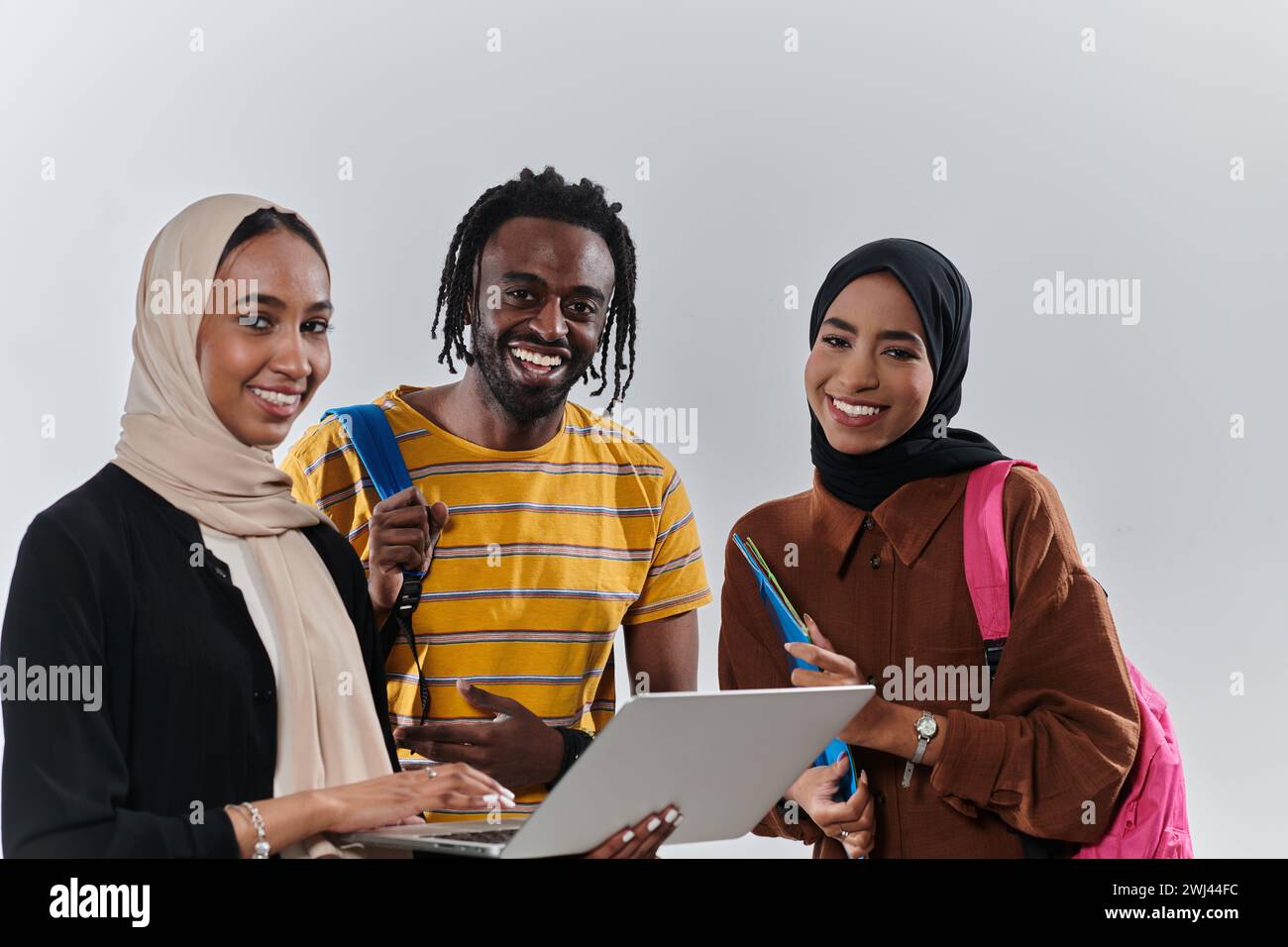 Un groupe d'étudiants, dont un étudiant afro-américain et deux femmes portant le hijab, s'unissent contre un BA blanc immaculé Banque D'Images