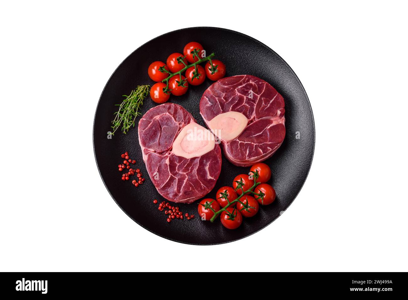 Steak de bœuf cru frais avec os ou ossobuco avec sel, épices et herbes Banque D'Images