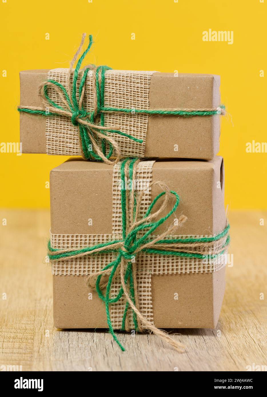 La boîte est emballée dans du papier artisanal brun et attachée avec une corde sur un fond beige, cadeau Banque D'Images