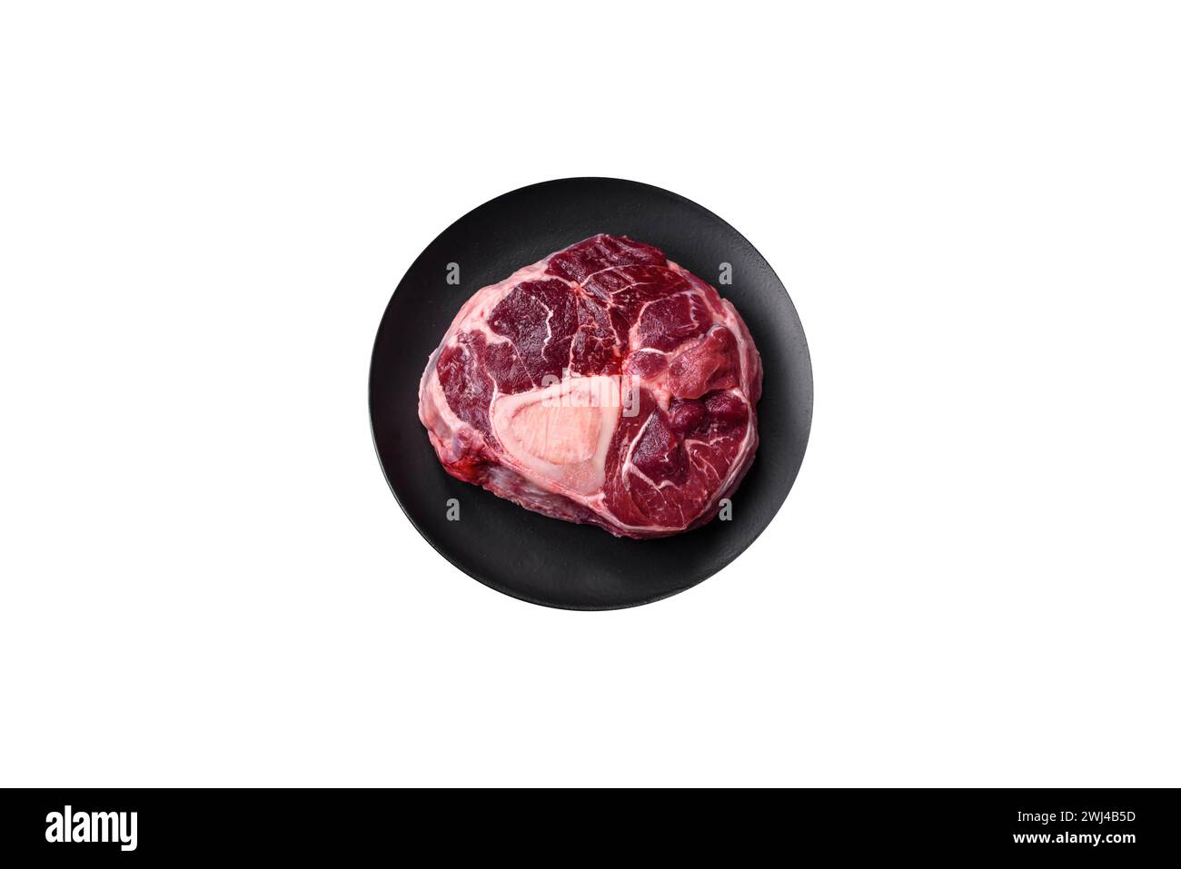 Steak d'ossobuco de bœuf frais avec sel, épices et herbes Banque D'Images