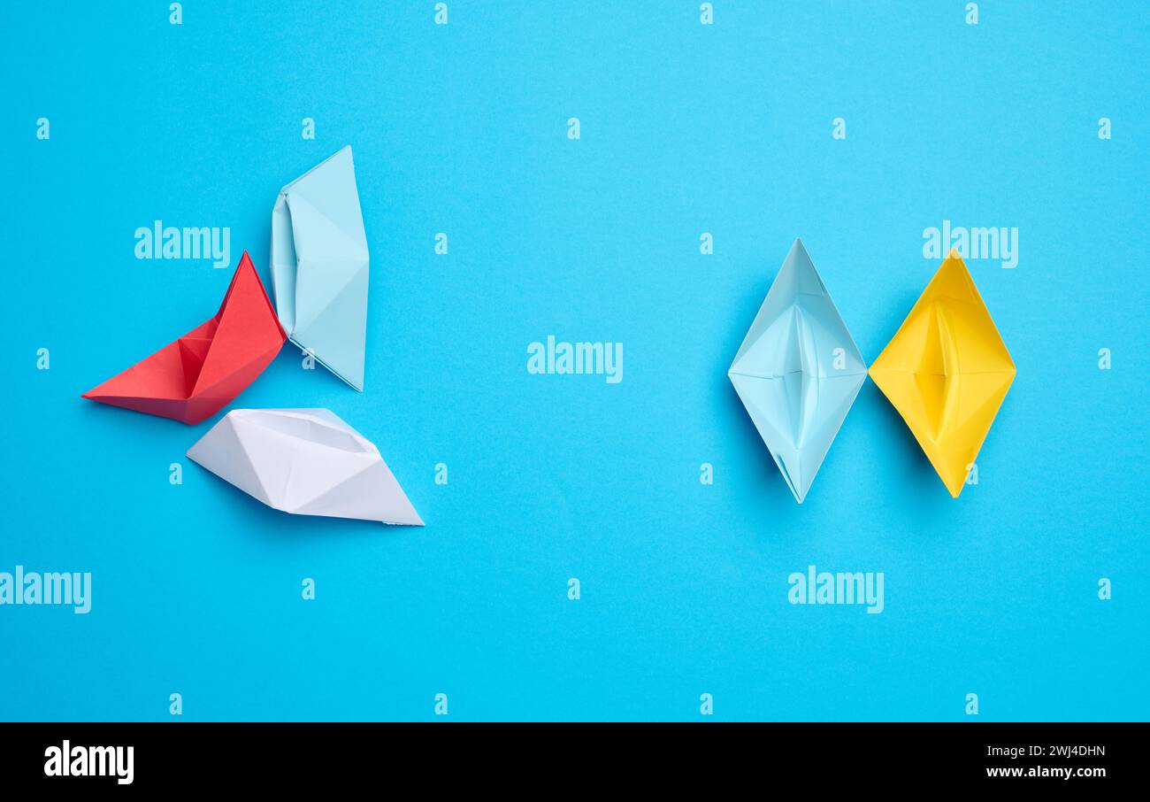 Un groupe de bateaux de papier avance, un autre quitte la distance Banque D'Images