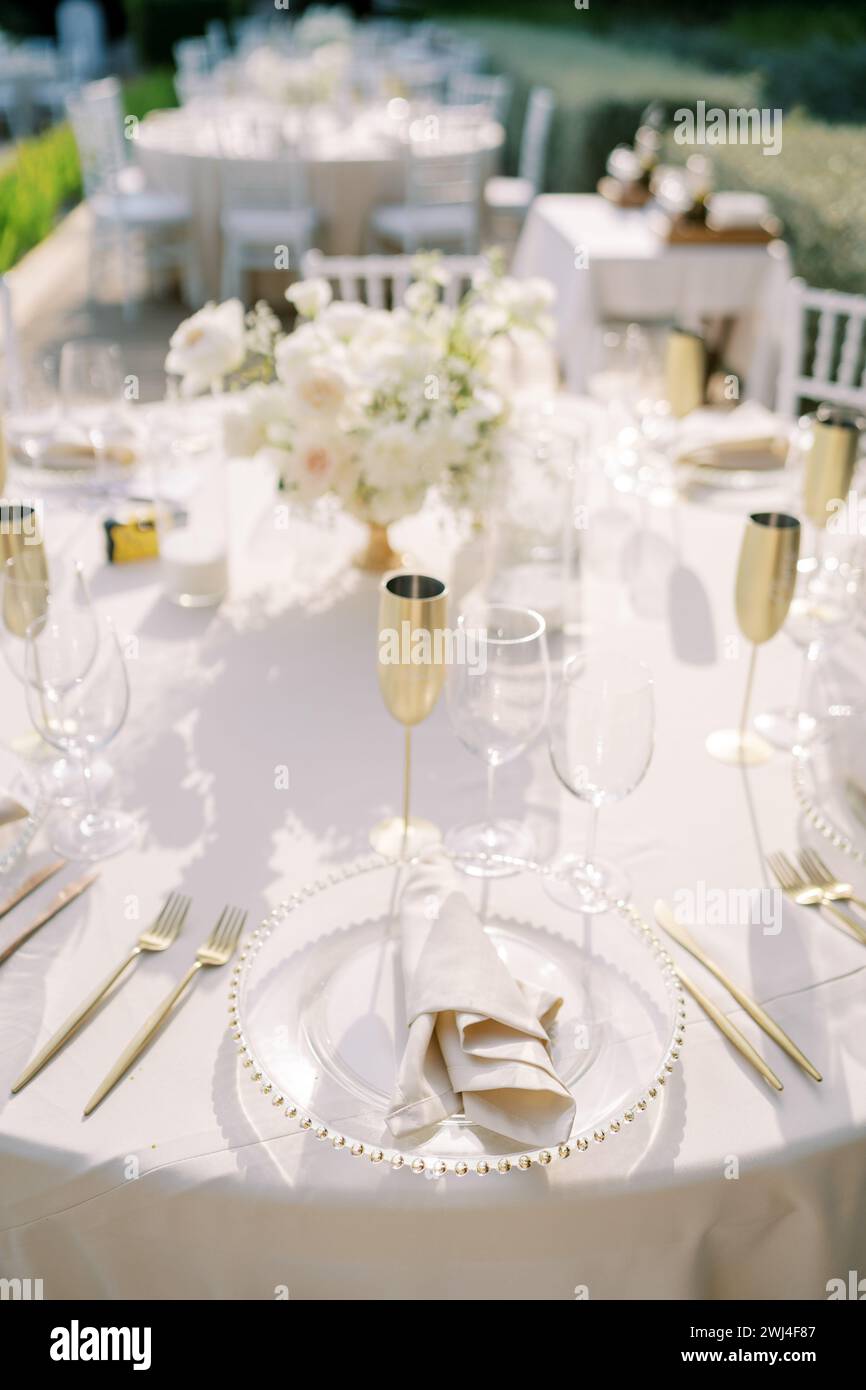 Set table avec verres et gobelets en bronze avec un bouquet de fleurs stands dans le jardin Banque D'Images