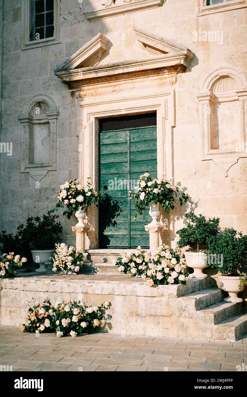 Mariage semi-arche avec bouquets de fleurs se dresse sur les marches de St. Mark Church. Perast, Monténégro Banque D'Images