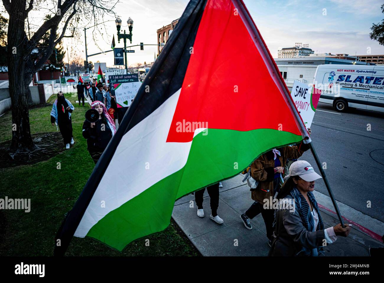 Bakersfield, Californie, États-Unis. 12 février 2024. Une femme porte le drapeau palestinien le 12 février 2024, à Bakersfield, en Californie, lors d'une manifestation d'urgence destinée à sensibiliser le public au bombardement ciblé de Rafah par Tsahal lors du Super Bowl LVIII. La ville de Rafah est devenue le dernier refuge du peuple palestinien assiégé à Gaza. (Crédit image : © Jake Lee Green/ZUMA Press Wire) USAGE ÉDITORIAL SEULEMENT! Non destiné à UN USAGE commercial ! Banque D'Images