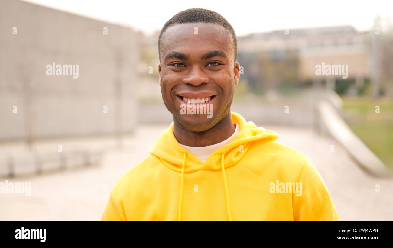 Un jeune homme africain debout et souriant Banque D'Images