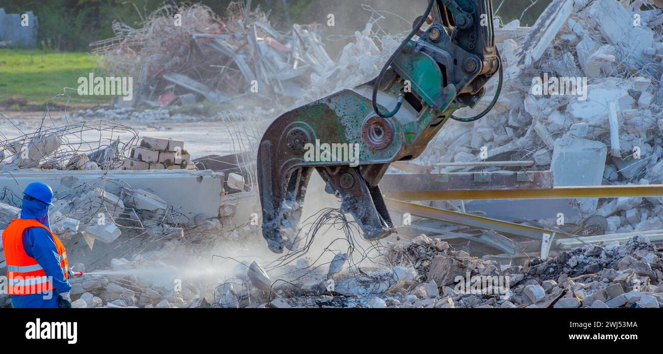 Démolition de bâtiments avec une pelle démolition sur un chantier Banque D'Images