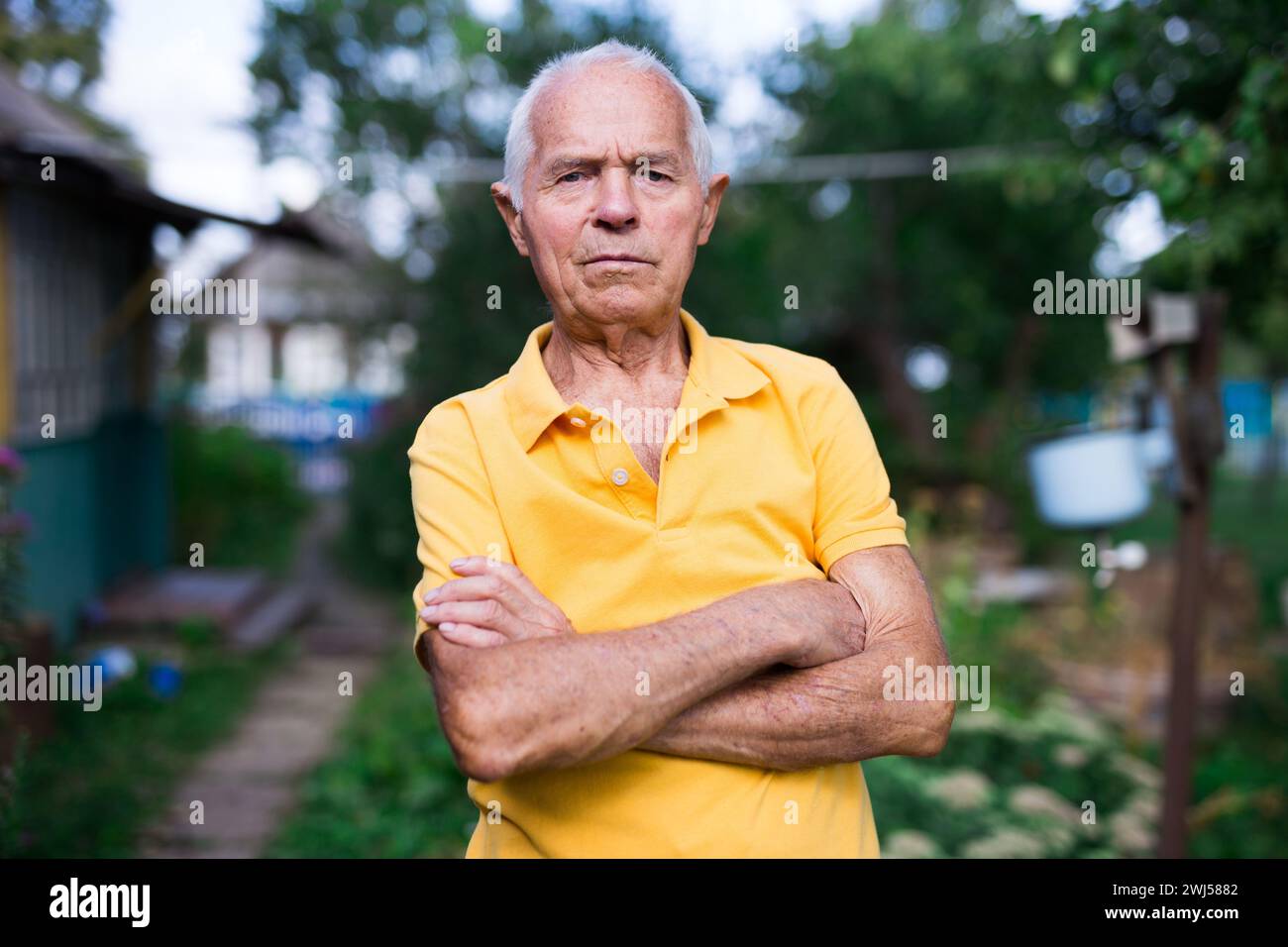 Portrait d'un homme âgé de 70 ans dans son jardin le jour ensoleillé d'été Banque D'Images