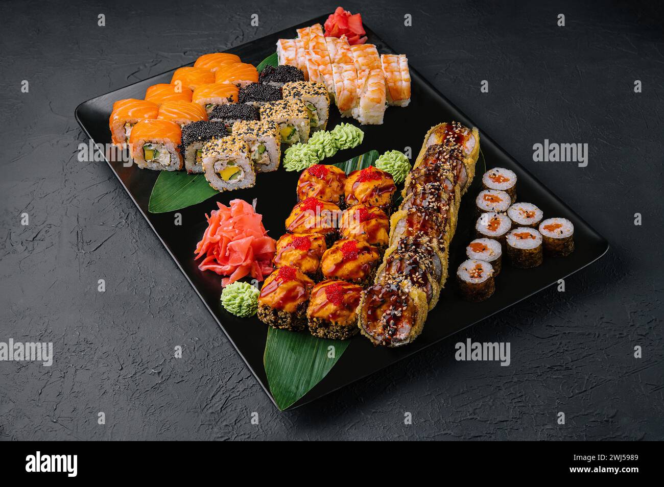 Sushis japonais assortis sur une assiette en pierre noire Banque D'Images