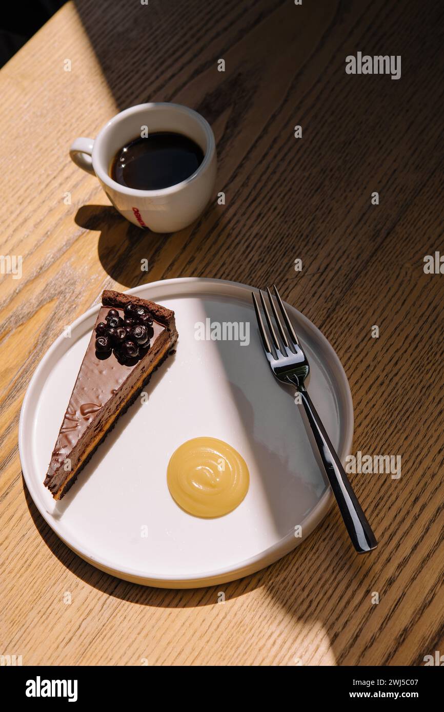 Gâteau au chocolat avec une tasse à café sur une table en bois Banque D'Images
